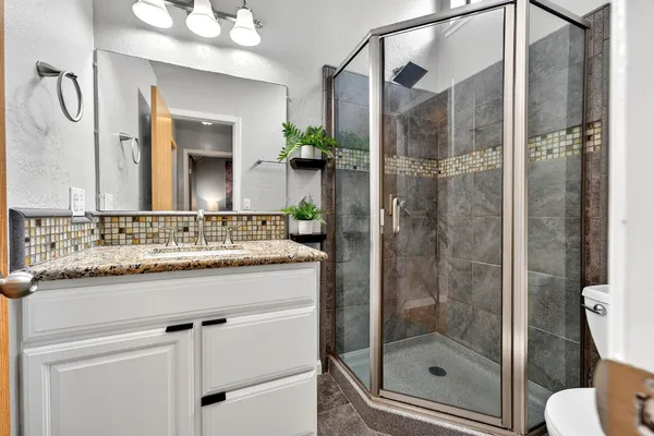 a bathroom with a shower sink vanity and mirror