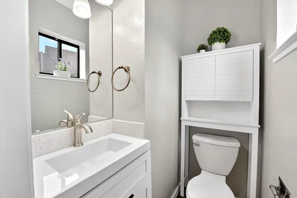 a bathroom with a toilet sink and mirror