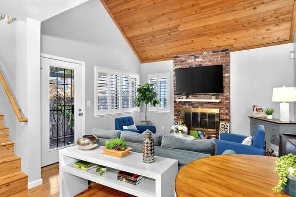 a living room with furniture a flat screen tv and a fireplace