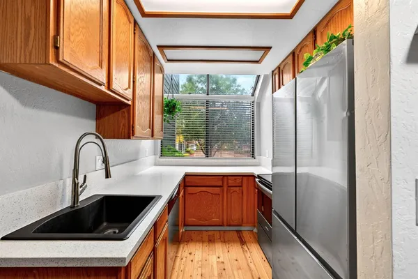 a kitchen with kitchen island a large window cabinets a sink and stainless steel appliances
