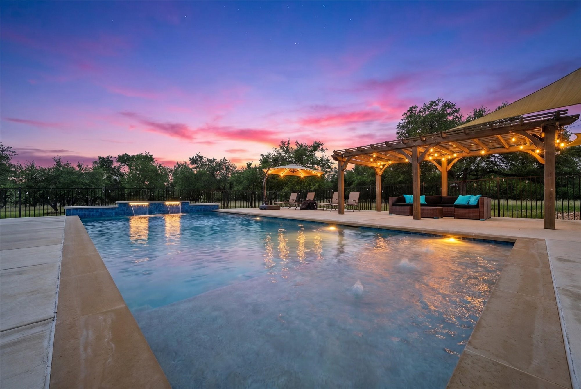 638 Strada Luca Florence, TX 76527 - Photo 30 of 38 An inviting backyard oasis offers a sparkling in-ground pool with elegant water features and a shaded pergola, perfect for twilight relaxation.