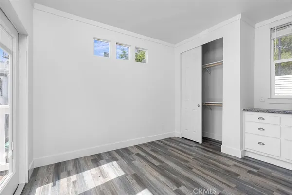 a view of a bedroom with wooden floor and window