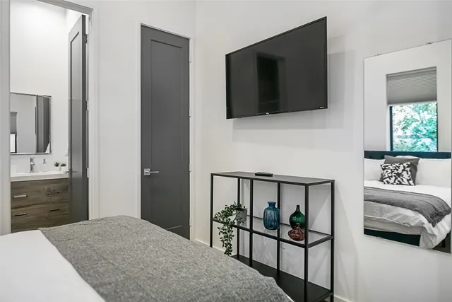 a bedroom with a bed and a flat tv screen on dresser