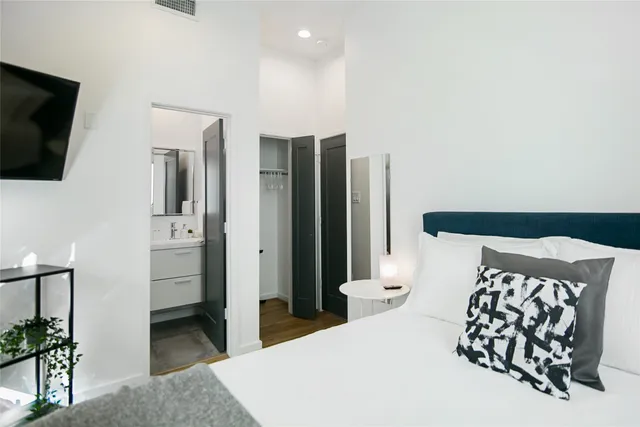 a bedroom with a bed and a flat screen tv