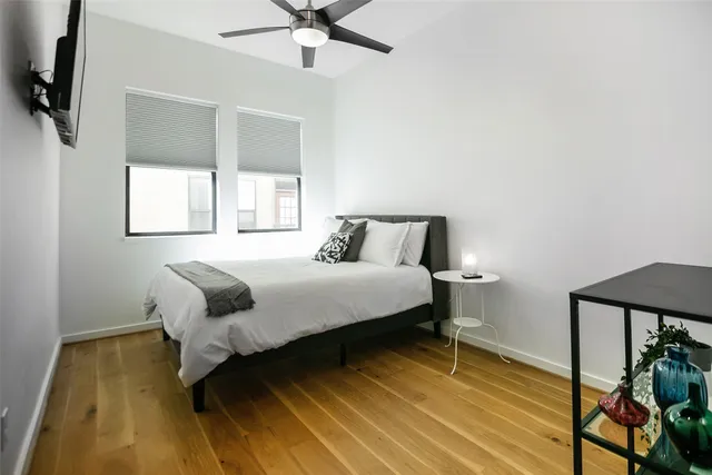 a bedroom with a bed and wooden floor