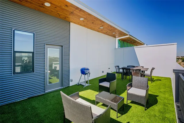 a patio with a table and chairs and potted plants