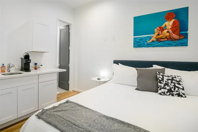 a bedroom with a bed and painting on the wall