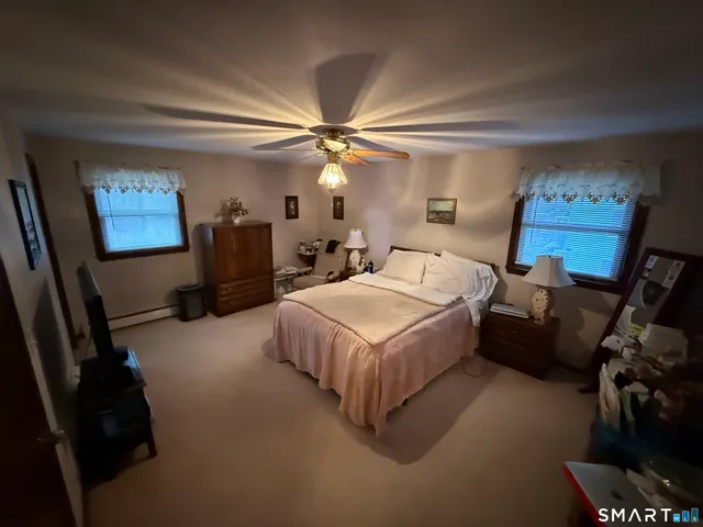 a spacious bedroom with a bed and a chandelier