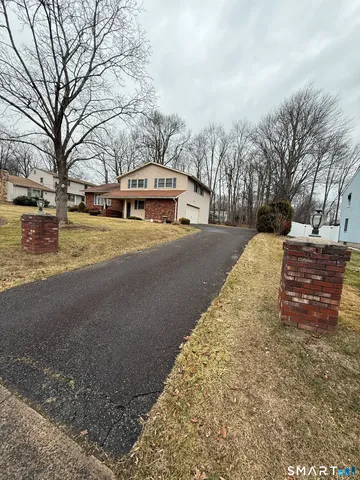 a front view of a house with a yard covered with snow