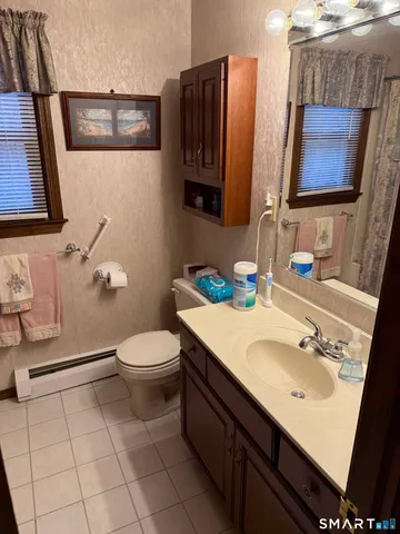 a bathroom with a sink a toilet and mirror