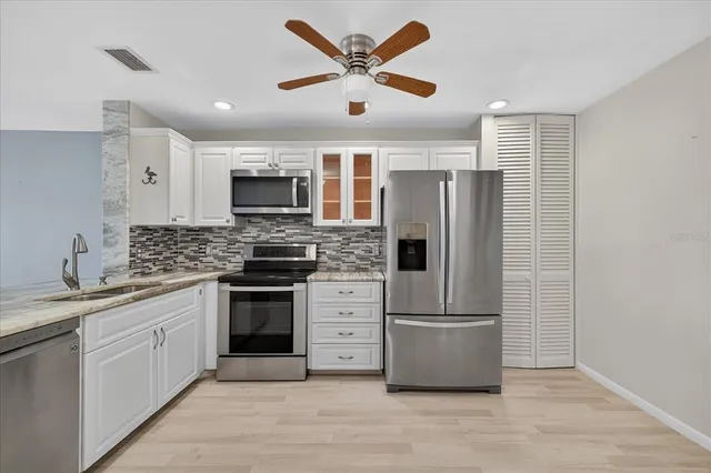 a kitchen with stainless steel appliances granite countertop a stove and a refrigerator