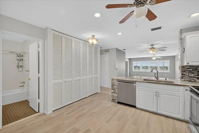 a kitchen with stainless steel appliances a stove a sink and white cabinets