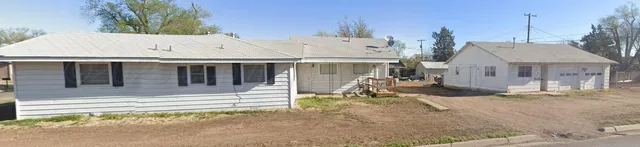 a front view of a house with a garden and plants