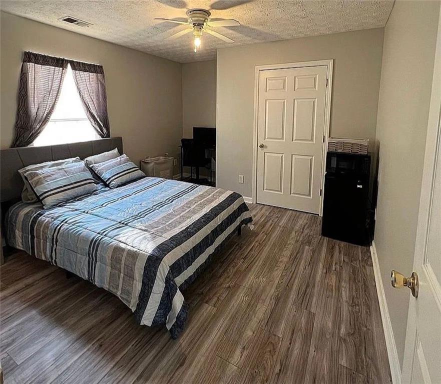 3267 Forrest Bluff Way Lithonia, GA 30038 - Photo 7 of 15 a bedroom with a bed and wooden floor