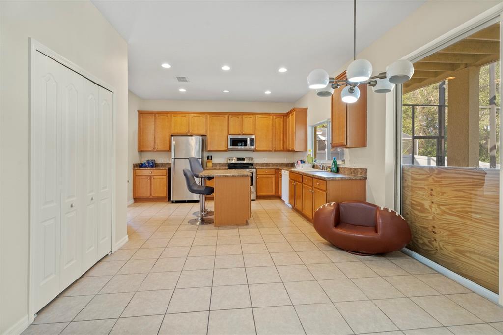 5042 Rishley Run Way Mount Dora, FL 32757 - Photo 11 of 44 a kitchen with stainless steel appliances kitchen island granite countertop a refrigerator and a sink
