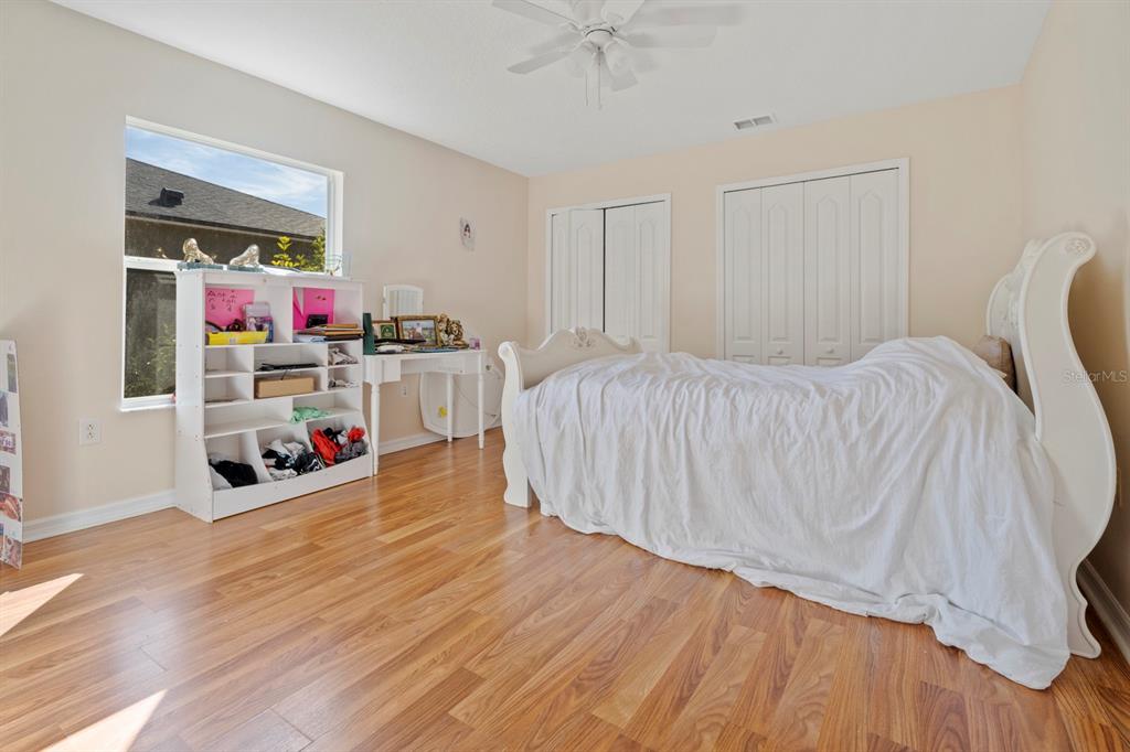 5042 Rishley Run Way Mount Dora, FL 32757 - Photo 25 of 44 a bedroom with bed and a wooden floor