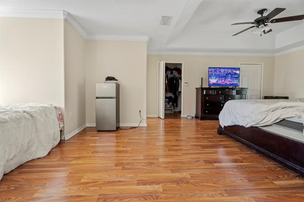 5042 Rishley Run Way Mount Dora, FL 32757 - Photo 27 of 44 a spacious bedroom with a bed and a walk in closet