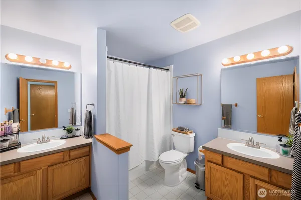 a bathroom with a granite countertop sink mirror vanity and toilet