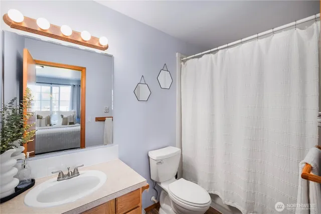 a bathroom with a sink a toilet and shower curtain