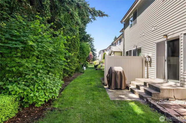 a view of a backyard with table and chairs and a barbeque