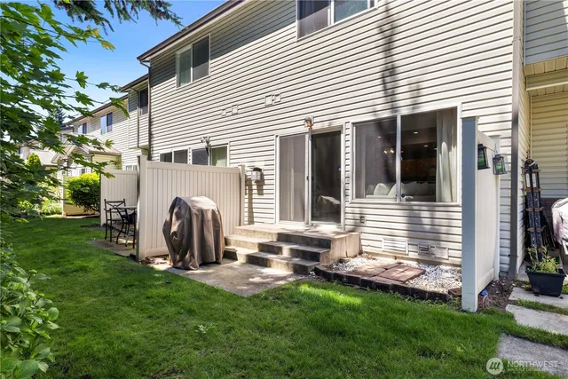 a view of a house with backyard and a tree