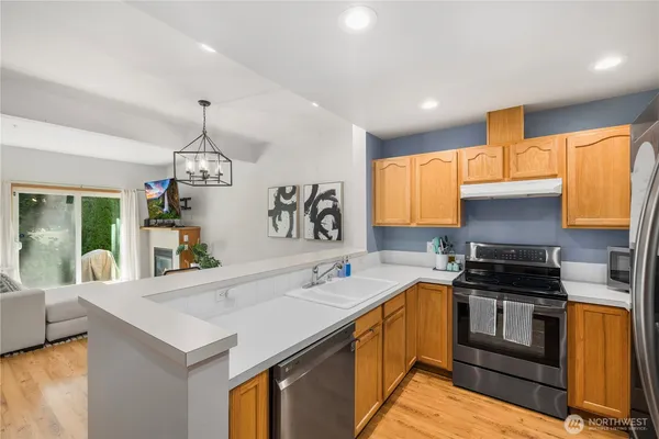 a kitchen with granite countertop stainless steel appliances a sink a counter space and a window