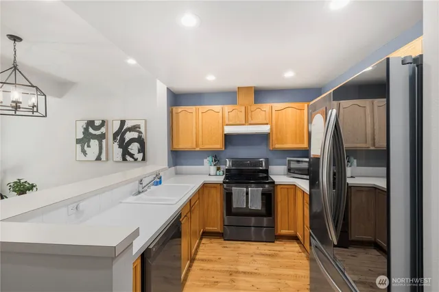 a kitchen with stainless steel appliances a sink stove and refrigerator