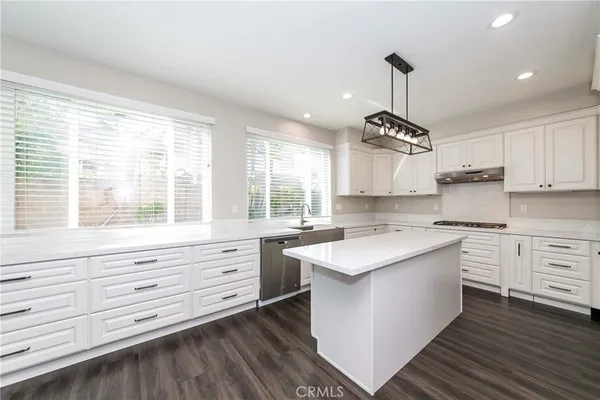a kitchen with granite countertop kitchen island white cabinets and white appliances