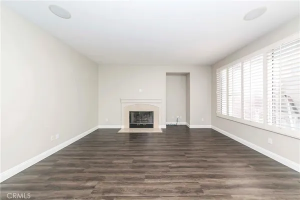 a view of empty room with wooden floor and fireplace