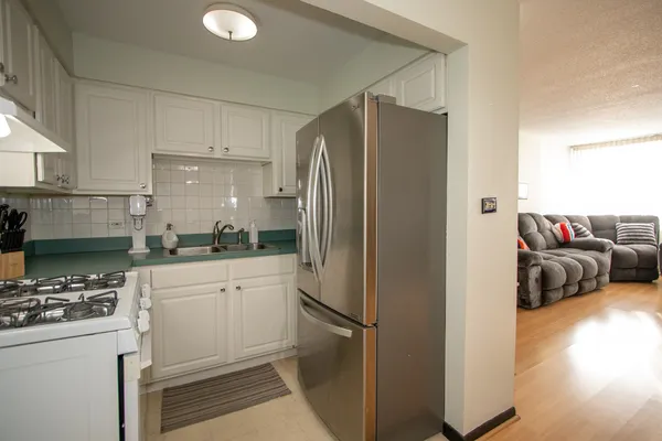 a kitchen with a refrigerator and a stove top oven