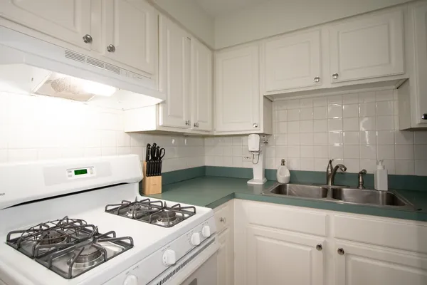 a kitchen with white cabinets and a stove