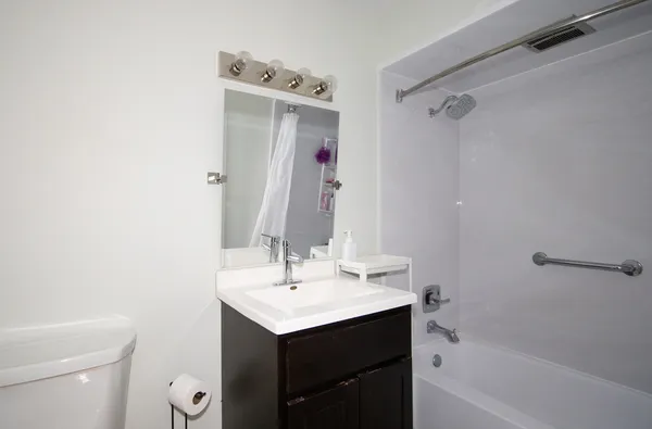 a bathroom with a sink a toilet and shower