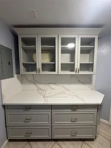 a room with a bed and a flat tv screen on the dresser