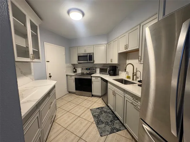 a kitchen with stainless steel appliances and white cabinets