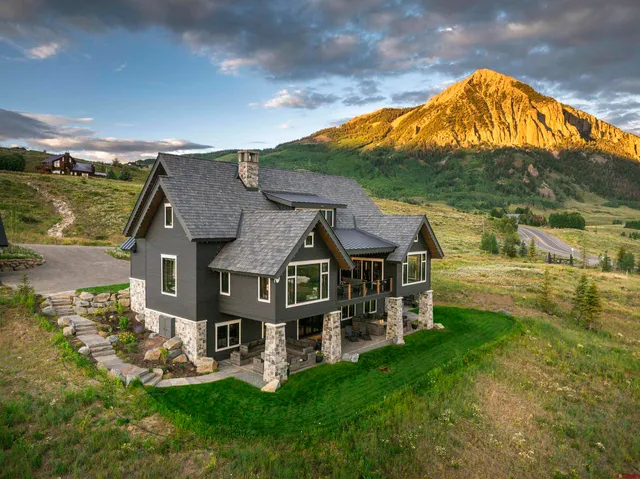 a view of house with green field and mountains