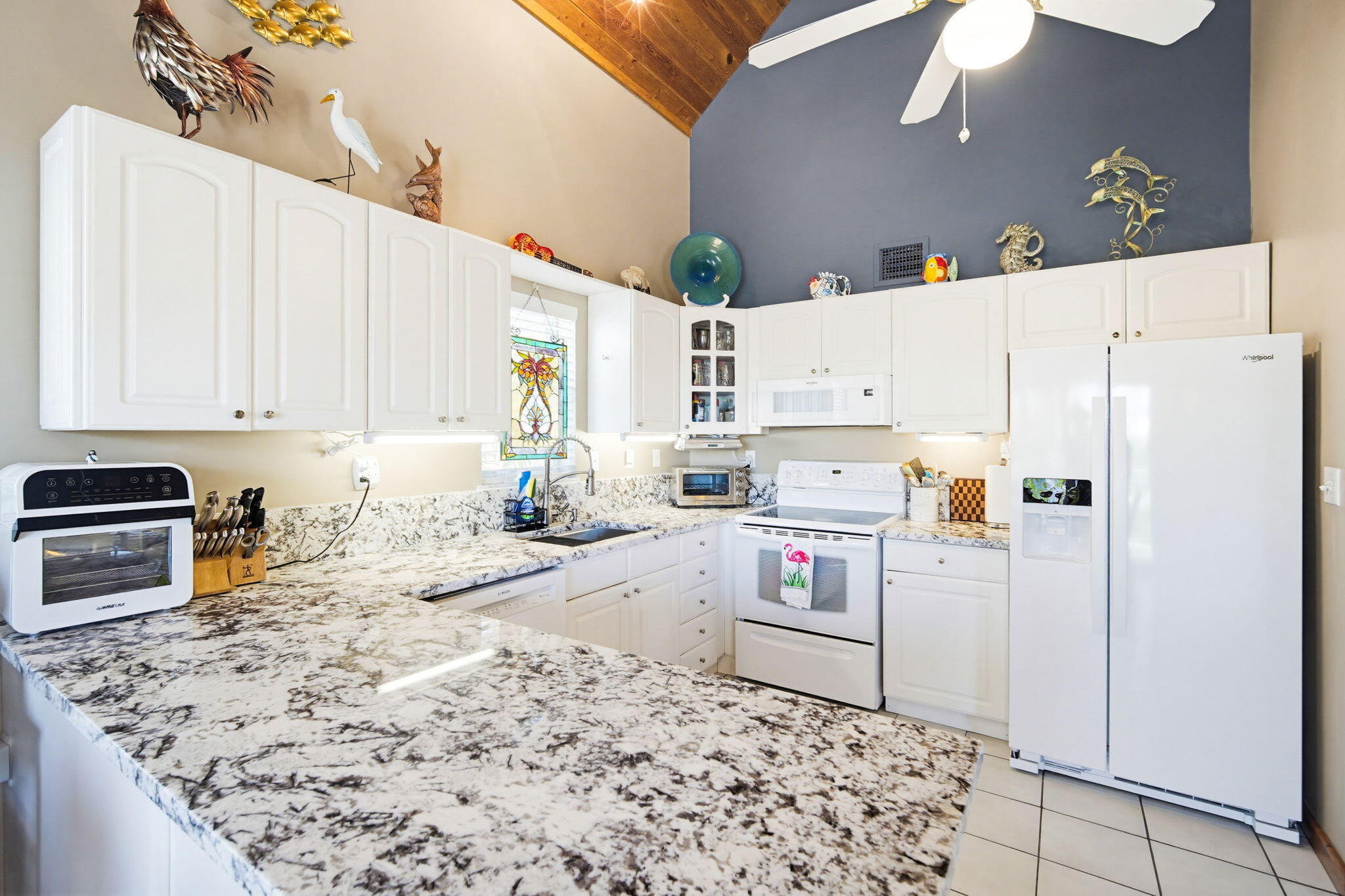 612 Blackbeard Road Summerland Key, FL 33042 - Photo 20 of 68 a kitchen with stainless steel appliances granite countertop a refrigerator sink stove and white cabinets
