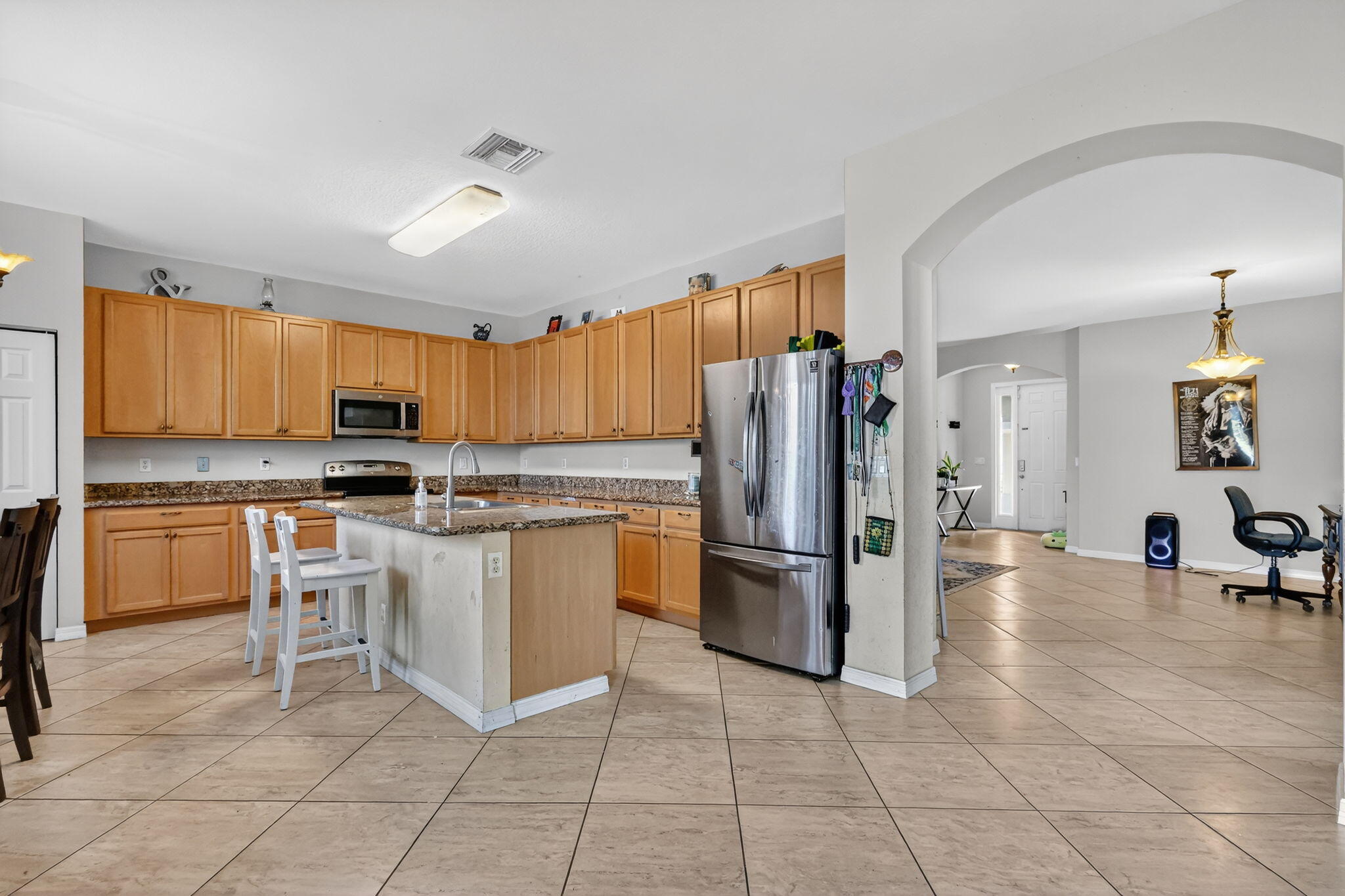 6720 Osage Circle Greenacres, FL 33413 - Photo 14 of 54 a kitchen with granite countertop a refrigerator and a stove top oven