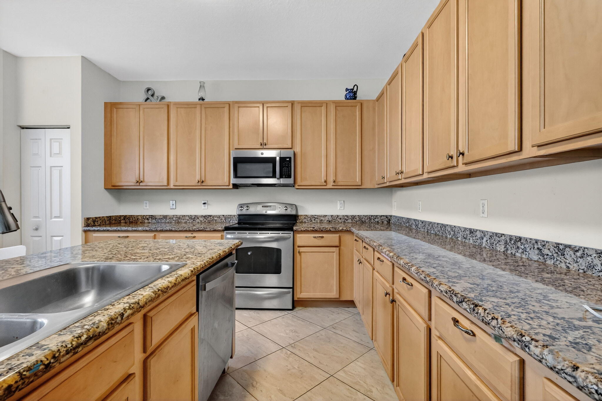 6720 Osage Circle Greenacres, FL 33413 - Photo 17 of 54 a kitchen with stainless steel appliances granite countertop a sink stove and microwave