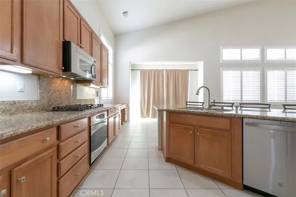 a large kitchen with stainless steel appliances granite countertop a sink and cabinets