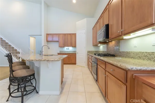 a kitchen with stainless steel appliances granite countertop a sink stove and cabinets