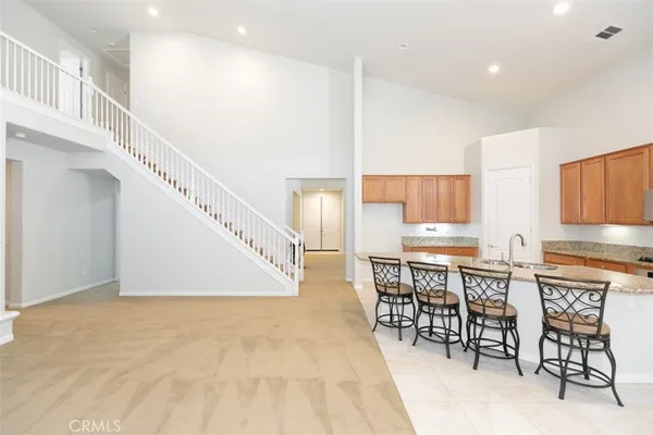 a kitchen with stainless steel appliances a table and chairs in it