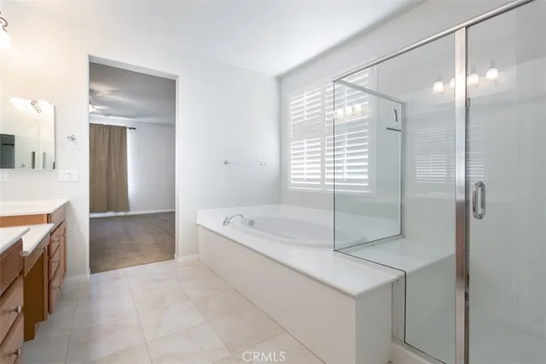 a spacious bathroom with a tub sink and mirror