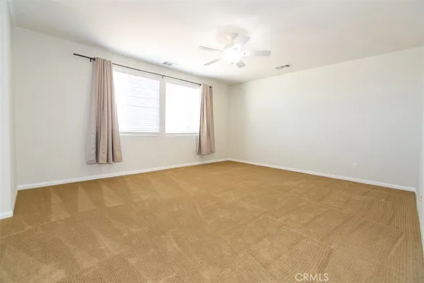 an empty room with a window and a ceiling fan