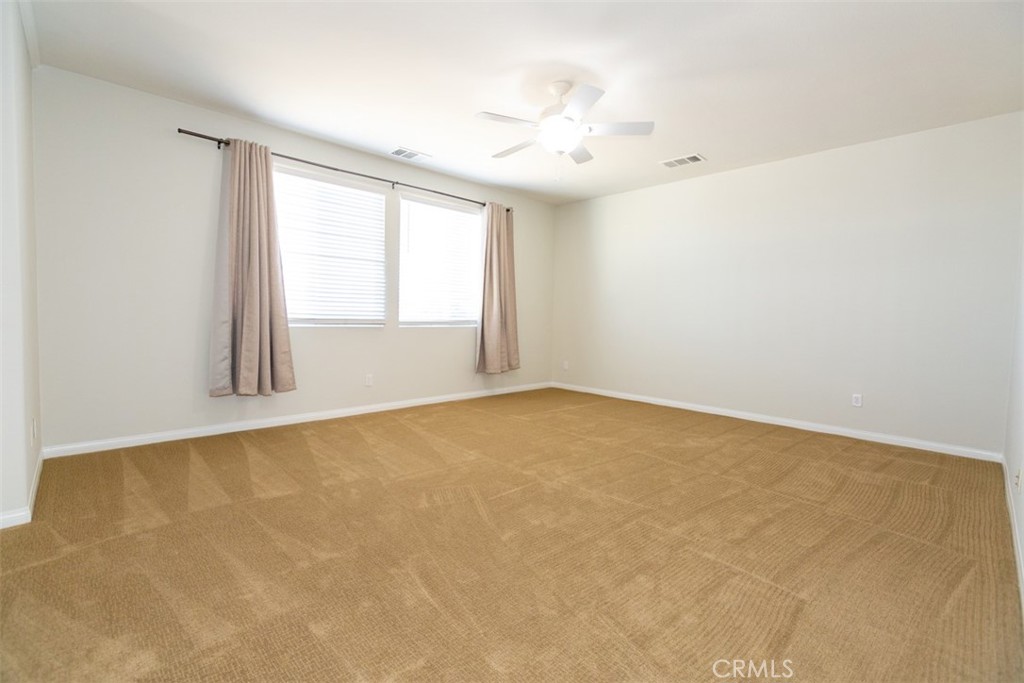 41640 Merryvale Lane Palmdale, CA 93551 - Photo 29 of 40 an empty room with windows and chandelier fan