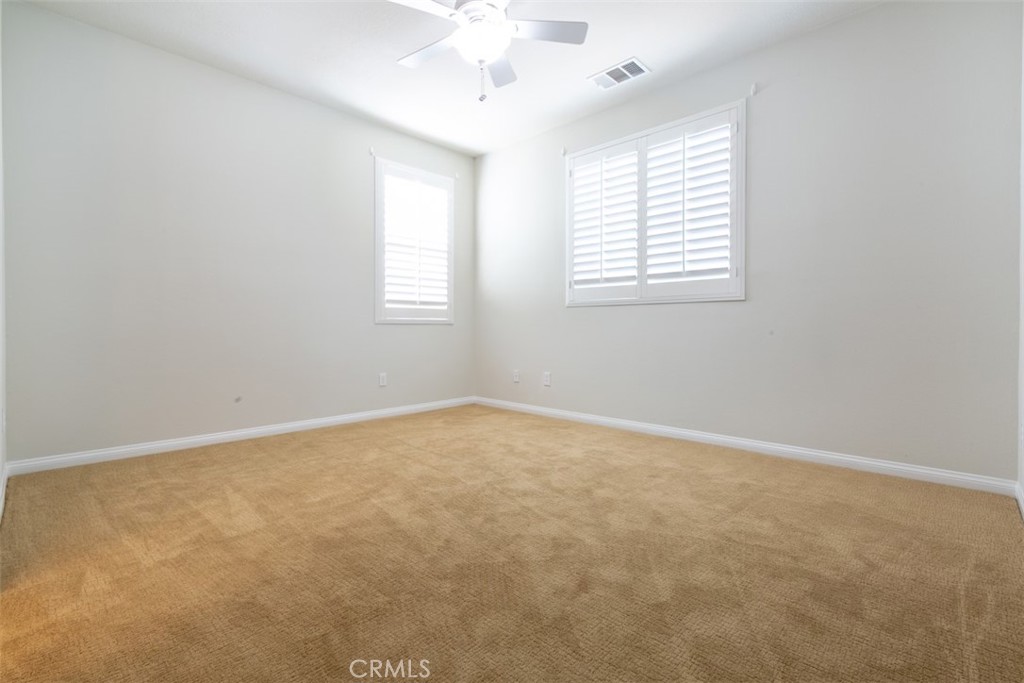 41640 Merryvale Lane Palmdale, CA 93551 - Photo 30 of 40 an empty room with a window and a ceiling fan