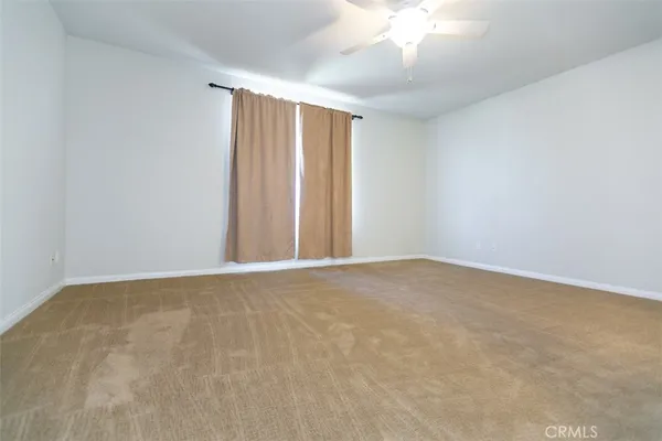 a view of a room with windows and ceiling fan