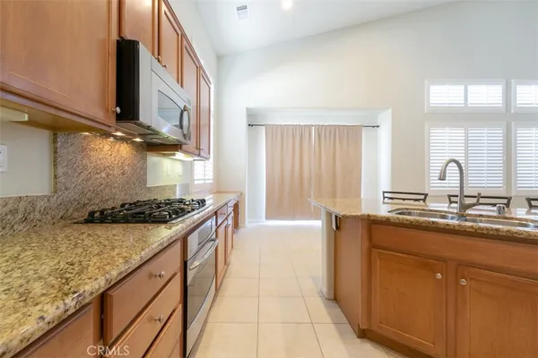 a kitchen with stainless steel appliances granite countertop a sink stove and cabinets