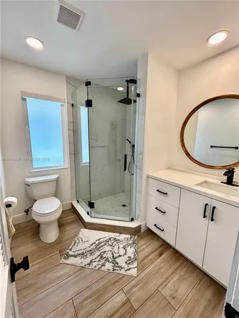 a bathroom with a sink mirror toilet and shower