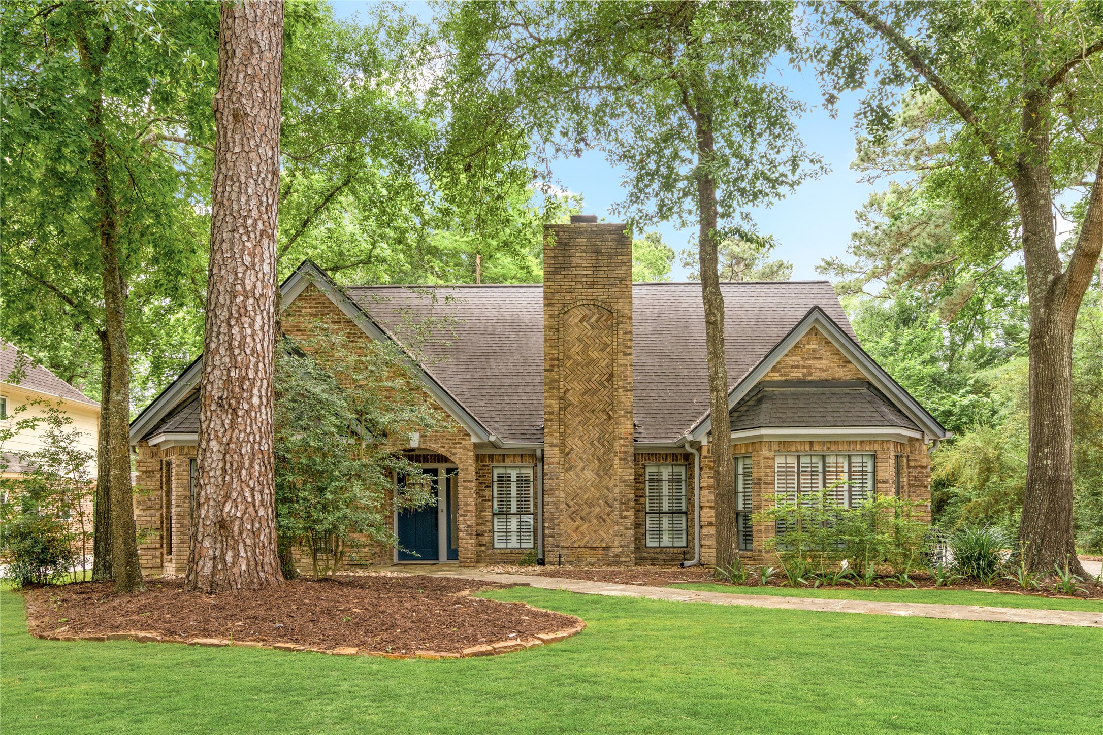 Beautifully updated home nestled among mature trees with exceptional curb appeal in the heart of The Woodlands.
