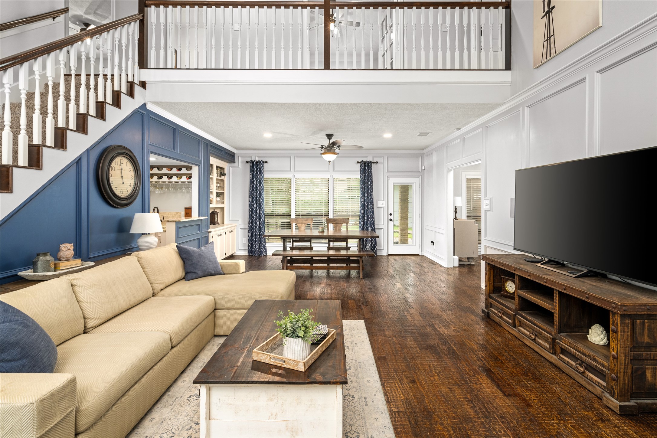 77 South Placid Hill Circle Spring, TX 77381 - Photo 4 of 48 Spacious two-story living room with custom hand-scraped wood floors, detailed trim work, and views of the backyard pool.